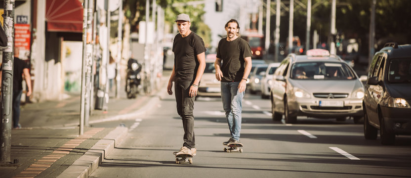 Two Skateboarders Riding Skateboard Slope On The City Streets