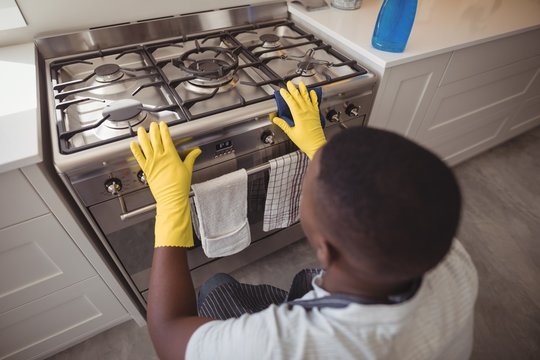 Man Checking Gas Stove In Kitchen