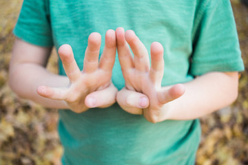 Hands of a little boy holding up 8 fingers