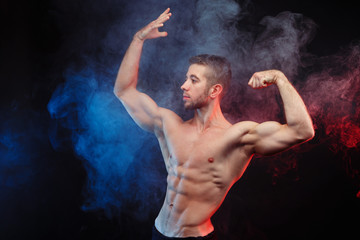 Obraz premium Young fit man bodybuilder with perfect big muscles. Muscled male model posing