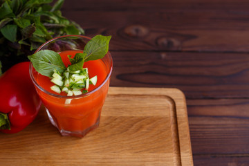 Diet concept, healthy lifestyle, low calorie food. Tomato smoothie with basil and cucumber. Detox and dietary eating on wooden table, copy space