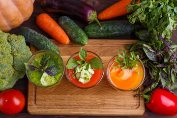 Diet concept, healthy lifestyle, low calorie detox and dietary food. Set of blended vegetable smoothies in glasses with ingredients on kitchen table