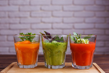 Diet concept, healthy lifestyle, low calorie detox and dietary food. Set of vegetable smoothie in glasses on wooden table, copy space