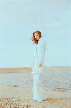 Fashion shot of young redhead woman wearing white clothes