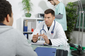 doctors consulting a young man in the hospital