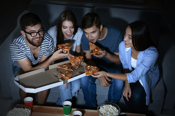 Friends watching TV in evening at home