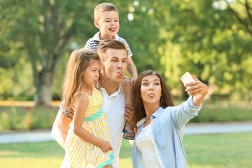 Happy family making selfie in park