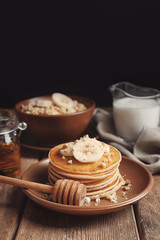 Plate with yummy banana pancakes on wooden table
