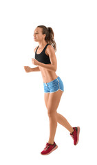 Beautiful young woman in sportswear running on white background