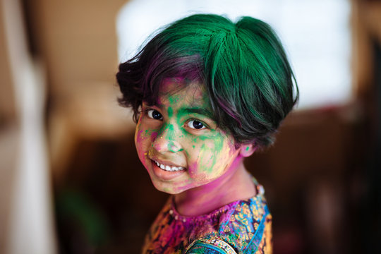 Portrait of cute little girl with colors on face