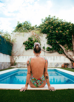 Young woman in the pool, turning her back at the camera