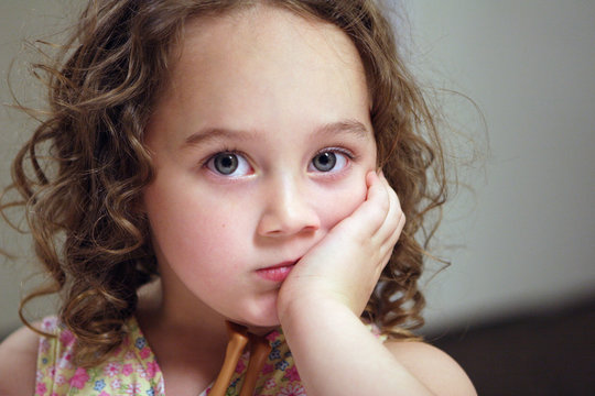 Curly Haired Girl Looking Bored Resting Hand Under Chin