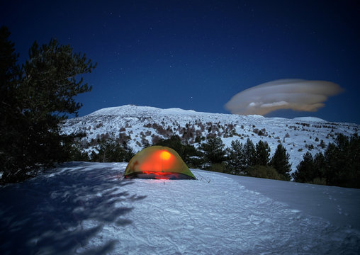 lighting tent, cloud formation and moonlight on winter Volcano Etna landscape, Sicily