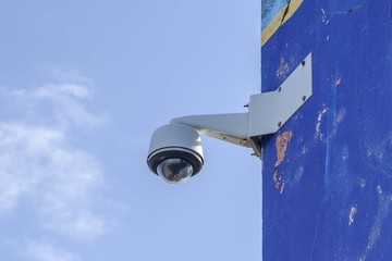white CCTV camera on a stone wall