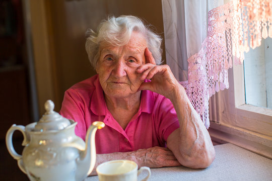 Portrait of elderly woman sitting at the tea table.
