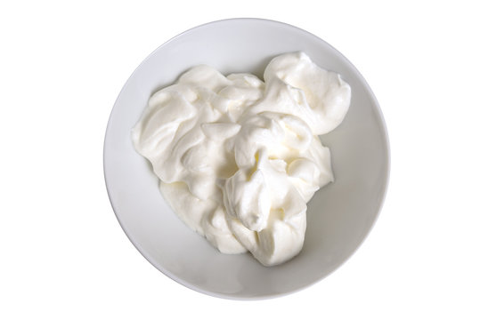 whipped cream in a bowl isolated on a white background, overhead view from above