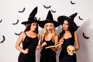 Three hot sorceress supersition spiritualists, practising occultism, with skeleton head, diabolic, satanic, devil, hex, wiccan exorcist paranormal ritual, dark spirits culture, astonished grimaces