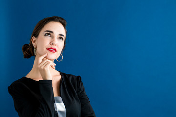 Young woman in a thoughtful pose on a blue background