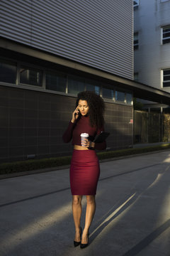 Business woman talking on cell phone holding a coffee mug