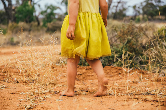 Little girl walking in the outback barefoot