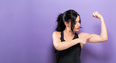 Powerful young fit woman on a solid background