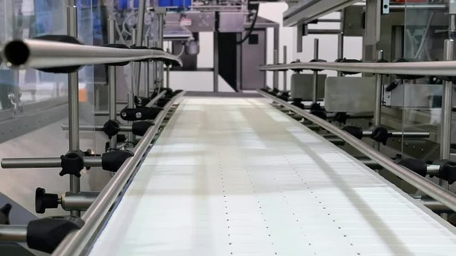 Food factory automated robotic machine. Conveyor product line for cooking and packing rations and food packs. Robotics and automatic lines used instead of human labor on factories and plants.