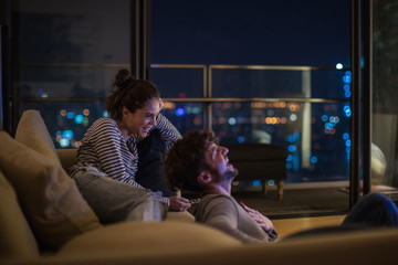 Young married couple sitting together and watching movie