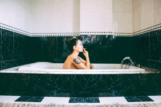 Portrait woman smoking in bathtub