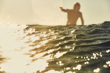 surfer passes behind a wave