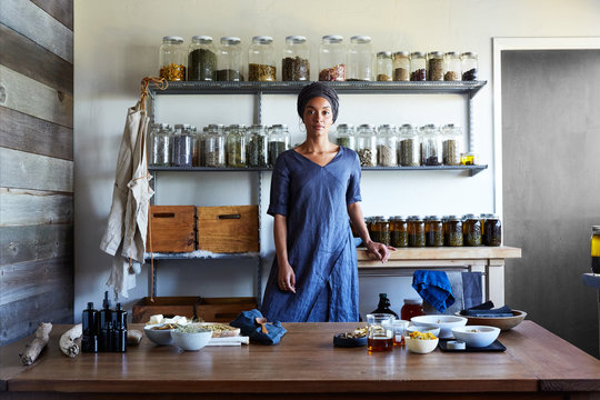 Herbalist stands in front of ingredients in her workshop
