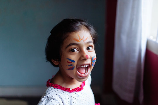 Little girl with a face paint having fun