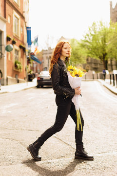 Young Beautiful Girl On the Street Holding Sunflowers