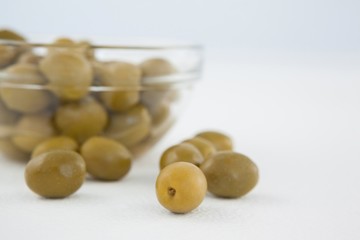 Close up of green olive by glass bowl