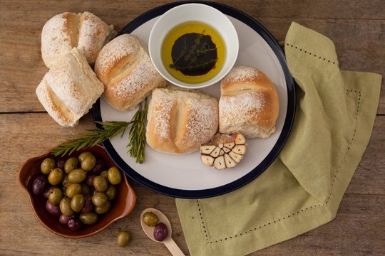 Overhead view of bread bread in plate by olives