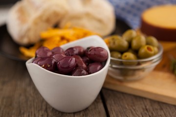 Olives in bowl by cutting board