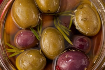 Close up of olives and herb with oil