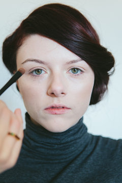 Beautiful woman in her twenties having make up applied