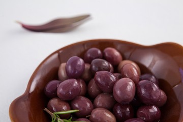 Close up of brown olives in wooden container