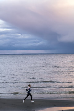 Picturesque view on girl running against of pastel colored sky