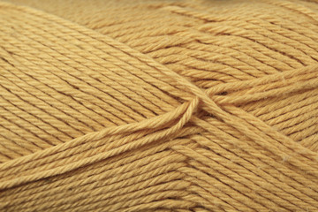 A super close up image of mustard yellow colored yarn