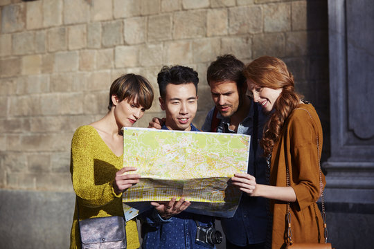 Happy Friends Looking At Map In City