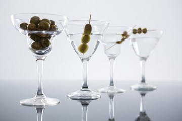 Cocktail martini with olives on table