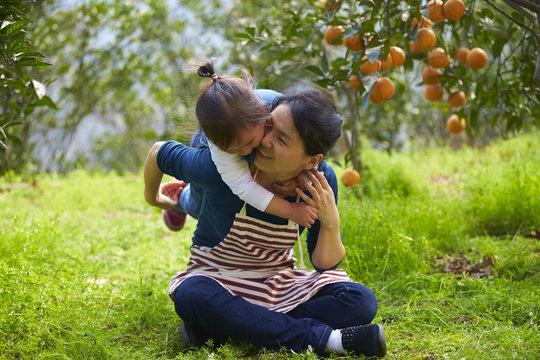 Little Asian Girl With Her Mother In The Orange Farm