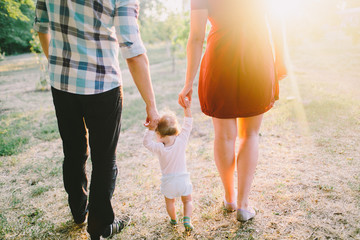 Parents walking away with thier little baby boy holding hands