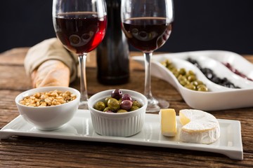 Close-up of marinated olives with glasses of wine
