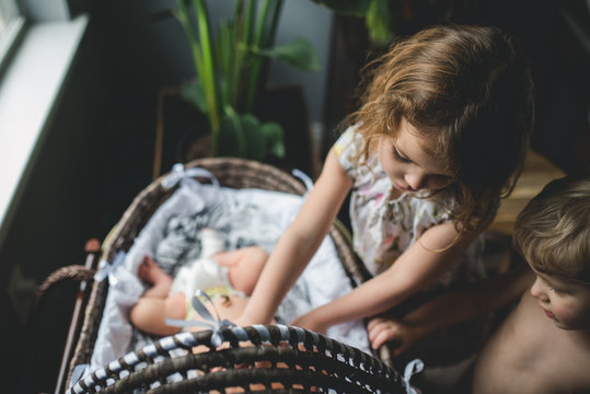 Siblings adoring new baby