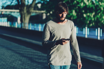 Fototapeta premium Hipster walks around the city with a phone.