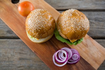 High angle view of cheeseburger with onion and tomato