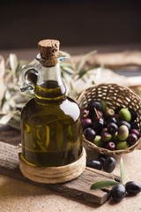 Olive oil and olives on wooden rustic table