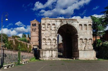 Fototapeta na wymiar Arch of Janus in Rome with old medieval bell tower